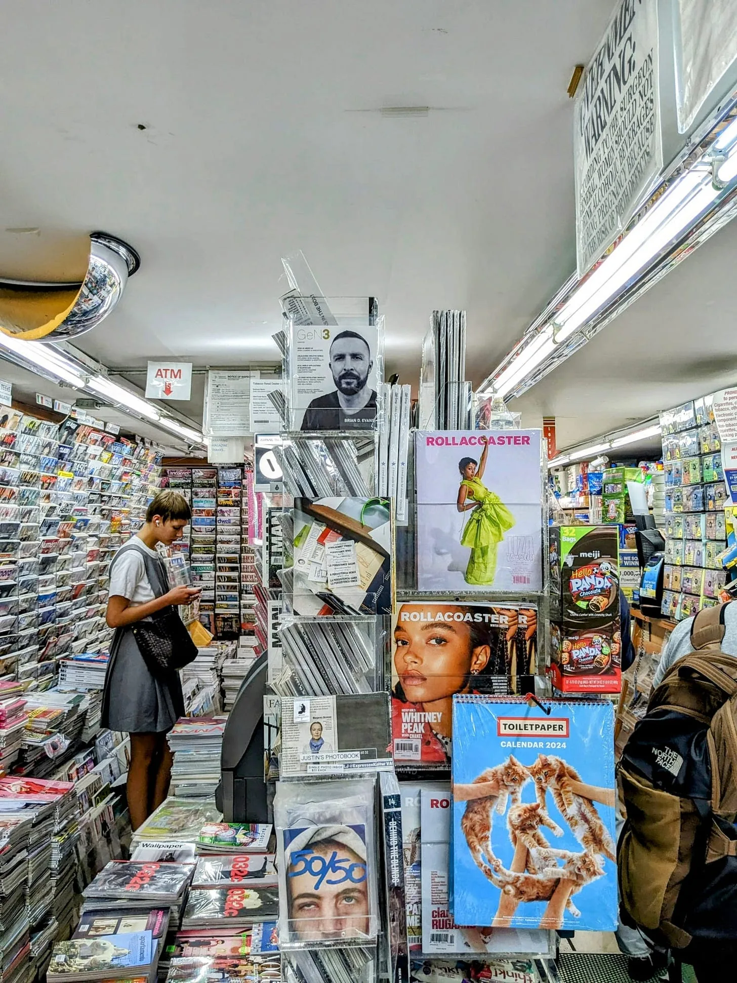 A crowded New York newsstand, shelves floor to ceiling with international magazines