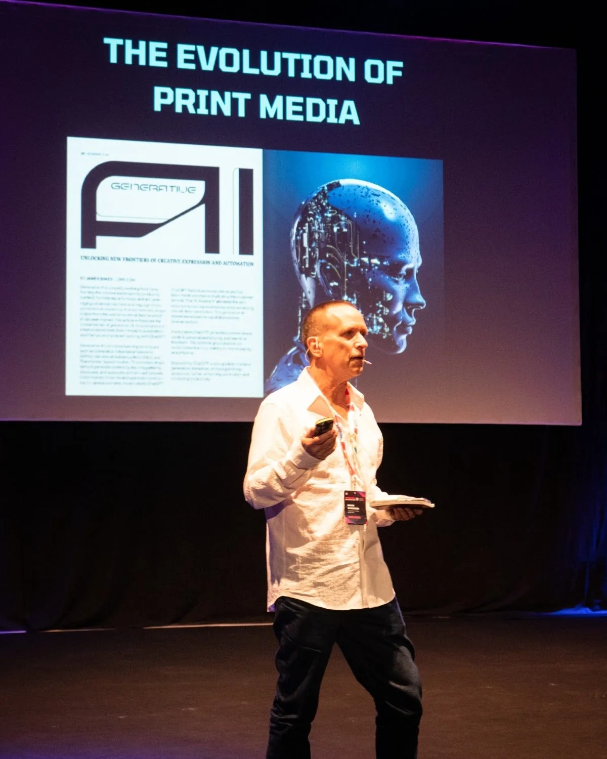Mark Barnard presenting on stage in front of a screen reading The Evolution of Print Media
