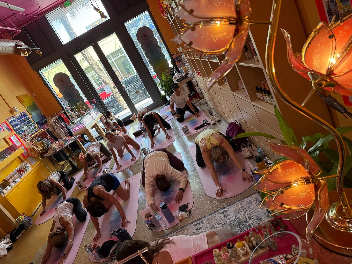 A group yoga class on pink mats inside a boutique Miami wellness studio